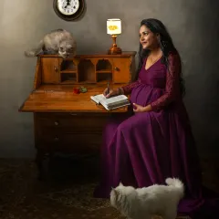 A whimsical studio portrait where an expecting mother writes in her journal, accompanied by her two curious cats. This image shows that cats are just as welcome as dogs in my sessions.
