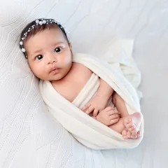 A perfectly swaddled newborn looking right at the camera. We are experienced in capturing these rare, beautiful moments when your baby is calm and awake during the session.