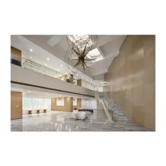 A wide view of the same lobby, showing how the staircase connects levels while defining the scale and proportion of the entrance hall. Its tectonics and detailing carry the architectural language of the entire building.