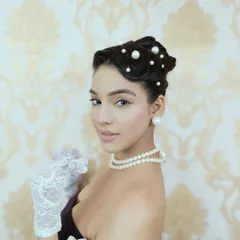 A close-up of a vintage-inspired updo from a themed editorial shoot. I meticulously crafted finger waves at the front and arranged a clean bun, scattering pearls throughout the hair for a touch of classic Hollywood glamour.
