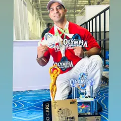 Dream it and achieve it. This is me surrounded by the fruits of our labor: Olympia medals, trophies, and an IFBB Pro Card earned by my team. This is the level of success we aim for.