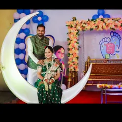 Capturing the joy of the parents-to-be is what it's all about. Here, a couple poses on an illuminated crescent moon prop, a popular photo-op I provide as part of my baby shower decoration services in the Thane area.