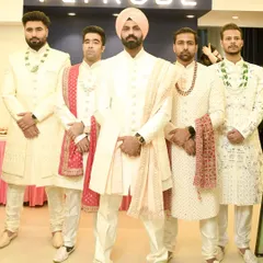 Here’s how you coordinate the groom and his squad. The dulha stands out in a turban while the groomsmen wear matching ivory sherwanis for a powerful, unified look.
