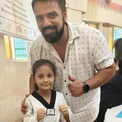 A proud moment for our student Zainab, posing with a supporter after her gold medal win. The support of family and friends is a huge part of a martial artist's journey.