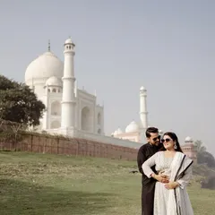 A candid moment by the riverbank, with the Taj Mahal in the distance. This shows a different, more rustic side of the location, adding variety to your Agra pre-wedding album.