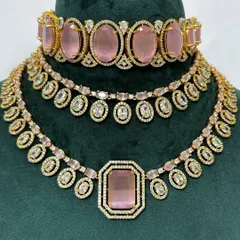 A stunning necklace set with pink stones and American diamond detailing. This rental set includes a choker and a matching necklace for a layered look.