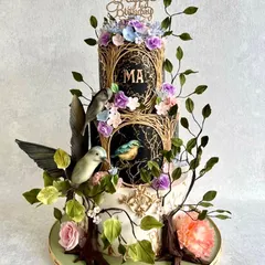 An enchanted garden theme for a special birthday. This three-tiered cake features hand-painted panels, sculpted branches, and delicate sugar birds and flowers. It was a labour of love.