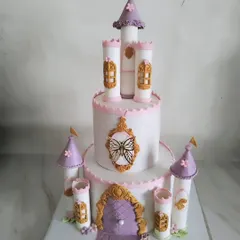 Here is a closer look at the castle cake. It's a two-tier design with towers, windows, and a grand door, all handcrafted to create a fairy tale centerpiece.