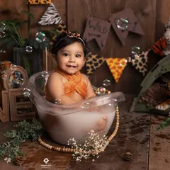 Bubbles, smiles, and a wild jungle theme. This bath session is full of fun details, from the animal print banner to the little tiger friends watching over her.