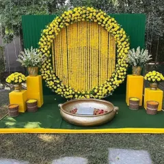My traditional Haldi setups are a specialty. This outdoor decoration features a classic genda phool (marigold) ring backdrop, a brass urli for the ceremony, and bright yellow pedestals, perfect for a sun-kissed event.
