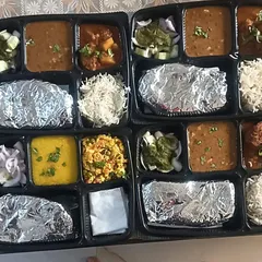 This image shows the variety I offer in a single day. One thali has kofta curry and dal makhni, while the other has paneer bhurji and yellow dal, catering to different tastes.