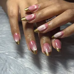 A glamorous set featuring a pink cat eye base with sculpted gold chrome on the tips. This is a bold and luxurious look.