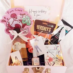A pretty-in-pink trunk box for her birthday. This hamper is filled with everything a girl loves: a face mask, dark chocolate, body scrub, nail polish, and a cute card.
