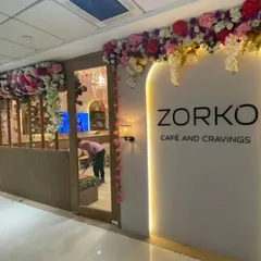 An elegant artificial floral installation framing the entrance of Zorko Cafe. This type of long-lasting decor is perfect for creating a sophisticated first impression for cafes, salons, and boutiques.