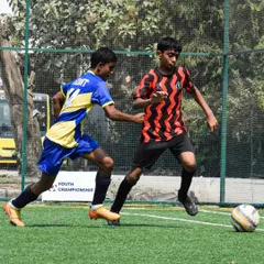 A young player in our academy's kit dribbling past a defender during a Youth Championship match. This is the on-field application of the ball mastery drills we practice.