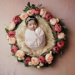 A perfect little blossom. This classic swaddle pose, with the baby wrapped tightly and placed in a nest of flowers, is a beautiful way to capture their tiny form.