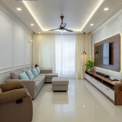 A perfect example of Scandinavian-inspired design, this living room uses a neutral color palette, a comfortable sectional sofa, and clean lines to create a calm and inviting space. The simple TV unit and wall molding add a touch of understated elegance.
