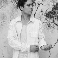 A clean and simple outdoor portrait against a textured wall. This black and white shot has a timeless feel, focusing on the model's natural look.