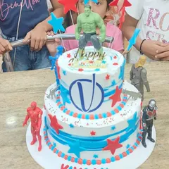 A fun two-tier Avengers cake with action figures, perfect for a young fan's party.