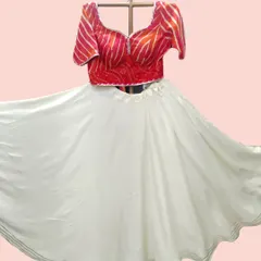 This white lehenga skirt provides a perfect canvas for the vibrant red bandhani and leheriya print blouse. The flared skirt is light and ideal for twirling during garba.