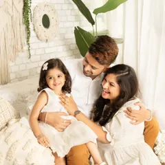 The best family photos are often the unscripted ones. This candid shot captures pure joy and laughter in a modern, light-filled setting. Coordinated white outfits give the session a fresh and contemporary feel, perfect for remembering these playful family moments.