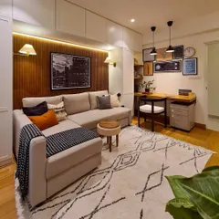 **AFTER:** The same room is now a multifunctional media room, guest space, and home office, complete with custom built-in storage, a cozy sectional, and a warm wood accent wall.