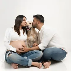 The couple kisses their happy dog from both sides, a beautiful and fun portrait that shows their complete family unit.