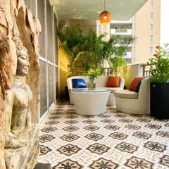 For this balcony makeover, we used bold, patterned floor tiles to create a strong design statement. The space is anchored by a serene Buddha sculpture and surrounded by tall areca palms, creating a tranquil, resort-like feel right at home.