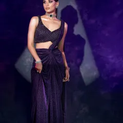 This image plays with shadow and light to create a dynamic composition, highlighting the shimmer and drape of the contemporary saree.