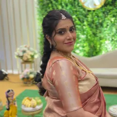 A happy client at her baby shower, her hair styled in a soft, romantic pull-through braid.