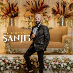 A dapper portrait of the groom, Sanjit. His confident pose against the elegant stage decor highlights his sharp style and the celebratory atmosphere.