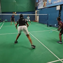 A doubles match in progress during a training session. We focus on teaching court positioning, communication, and tactical plays specific to doubles badminton.