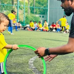 A coach guides one of our little kickers through an agility exercise with a hoop. We use fun equipment to develop motor skills, coordination, and balance in our 3 to 5-year-old players.