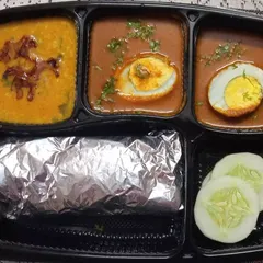 An egg lover's delight. This thali comes with a flavorful egg curry, wholesome dal, rotis wrapped in foil to stay warm, and a fresh cucumber salad for a complete meal.
