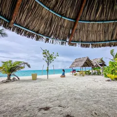 Post-dive relaxation is a key part of the experience. Here, a diver enjoys the serene beauty of a white sand beach in Gaafaru, the perfect way to unwind after a day of exploring the reefs.