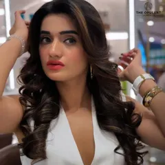 A candid shot showcasing the beautiful movement and texture of the hairstyle. The highlights catch the light perfectly, adding dimension to the voluminous curls.
