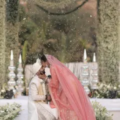 A sweet kiss seals the promise amidst a magical shower of petals. We work with our photo and video crews to capture these fleeting, emotional moments during the Varmala ceremony.