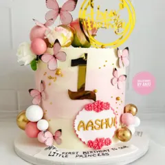A full view of this enchanting first birthday cake. The soft pink and white tones, combined with delicate butterflies and a bold number one, make it perfect for a princess.