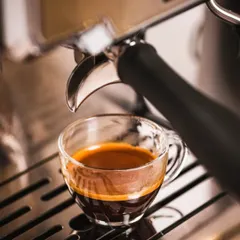 An espresso shot being pulled from a professional machine. We focus on capturing the rich color and texture of the coffee as it flows, a key visual for any cafe or coffee equipment brand that wants to emphasize quality and expertise.