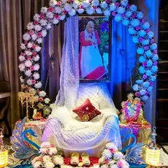 For an intimate home darbar, I created this serene setup. A beautiful circular arch of pink and white flowers frames Guru Ji's portrait, with a gracefully draped gaddi and peacock-themed props. This design shows how even a small space can be transformed into a sacred corner with detailed floral work.