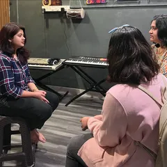 An instructor provides personalized guidance during a vocal session. We offer expert training for all ages in a supportive and focused environment.