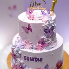The butterfly and floral cake on display at a party, looking absolutely magical.