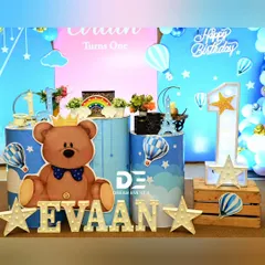 A closer look at the details for Evaan's party, including the crowned teddy bear, hot air balloon props, and a large light-up number '1'.