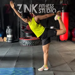Balance and flexibility are just as important as strength. This client is holding a dancer's pose, a yoga-inspired stretch that improves stability in the standing leg while opening up the chest and shoulders.