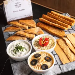 Our culinary range extends far beyond India. This fresh Mezze Platter, with creamy hummus, flavourful dips, and warm pita, is a perfect example of the authentic global cuisines we offer.