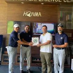 An Instructor Presenting an Award at the Men's Golf Camp: We celebrate progress and achievement at every level. An instructor presents a prize to a participant during the closing ceremony of the Men's Golf Camp, recognizing their performance in the camp's challenges.