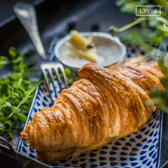 A classic butter croissant, served simply. Its beauty lies in the technique of lamination, creating those delicate layers. It’s the perfect companion to a cup of coffee or tea.