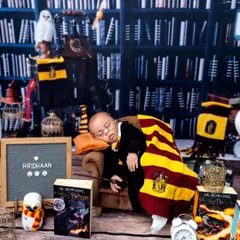 The full Hogwarts setup, featuring baby Hridhaan sleeping soundly in a miniature armchair. I include lots of details like the books, an owl, and a letter board.