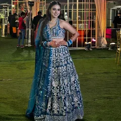 A happy client looking radiant in a peacock blue lehenga with dense silver embroidery. This is a popular rental for its rich color and festive look, perfect for a wedding guest or bridesmaid.