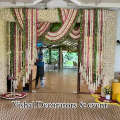 Our team member putting the final touches on a grand floral entrance made of tuberose and marigold garlands for a traditional wedding.